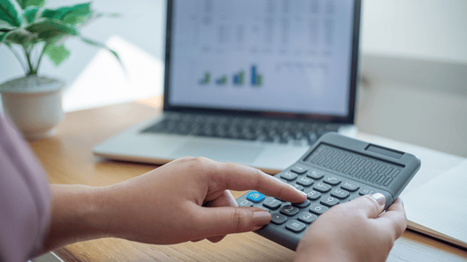 A laptop computer showing a report with the laptop user using a calculator.