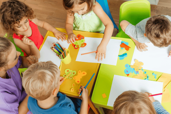 Aerial view of preschool children making a butterfly art project.