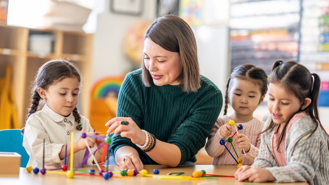 A childcare staff is interacting with children through activities.