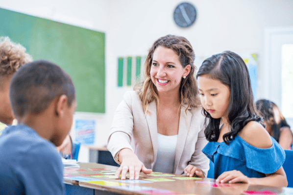 Teacher with children in preschool classroom.