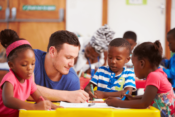 Teacher and students coloring with crayons