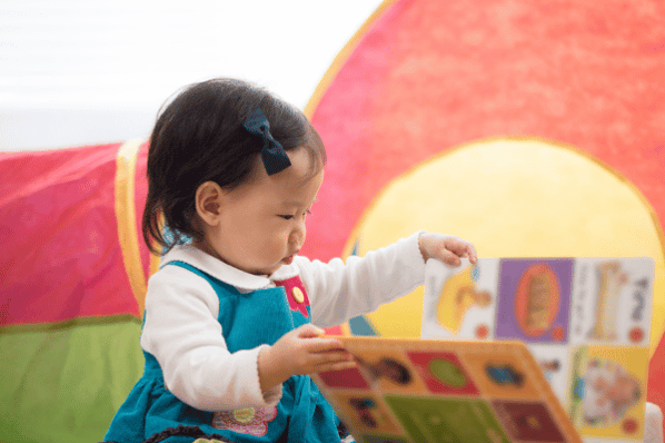 Toddler looking at a colorful picture book