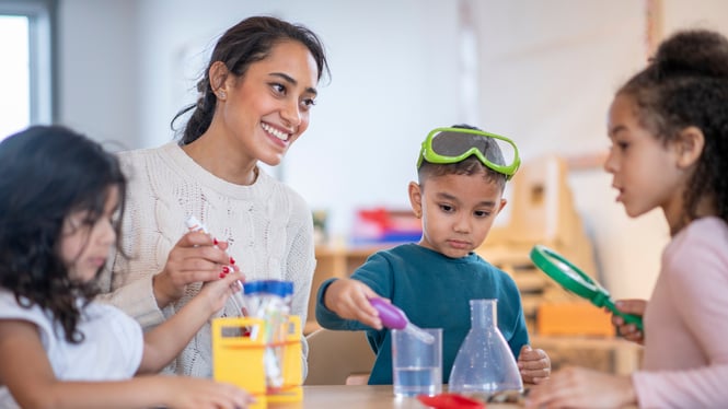 A childcare staff is interacting with a child through science activities.