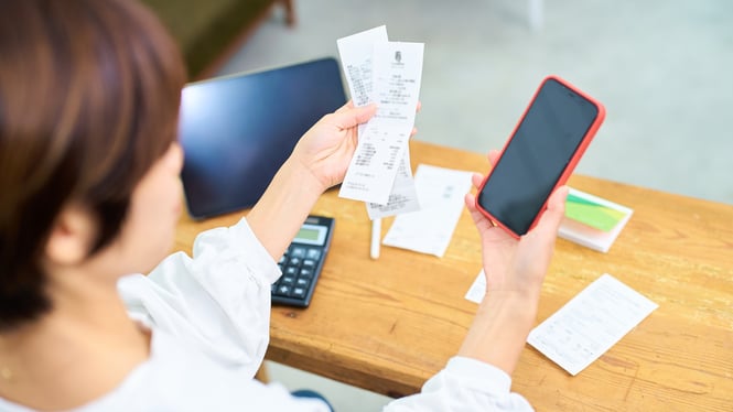 A childcare business owner keeping track of business expense receipts with a smart phone.