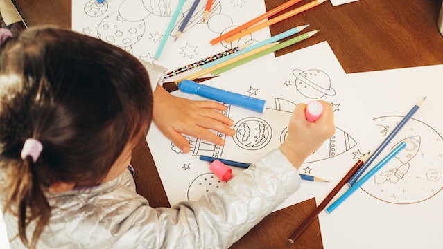 young girl coloring on paper