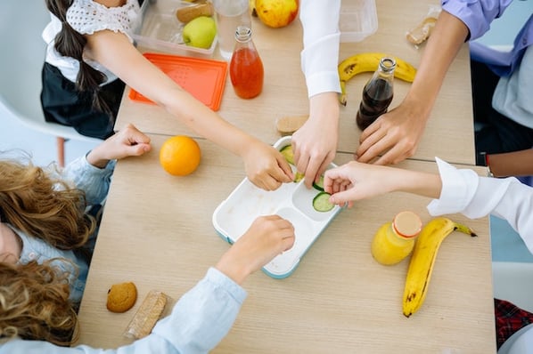 Children sharing a snack at a table