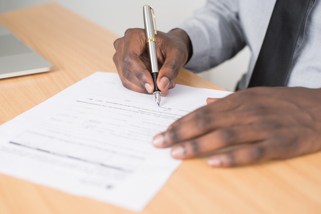 Person holding pen fills out paperwork