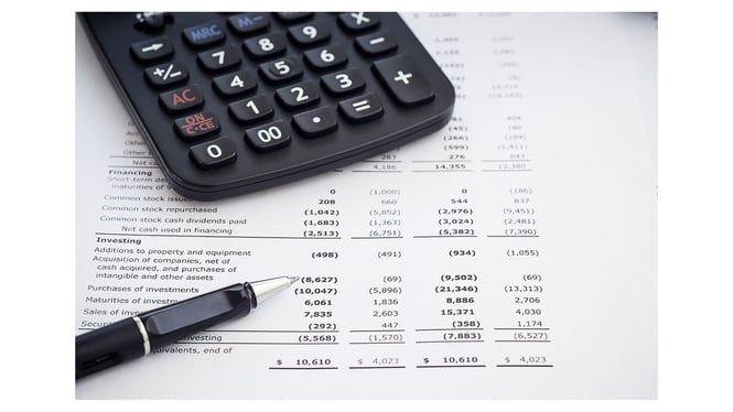 a printed income statement with a calculator and a pen