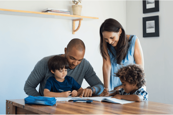 Parents helping young children with homework.