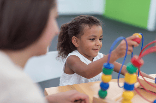 Therapist doing play therapy with young girl.