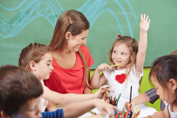 Child raising her hand in preschool.