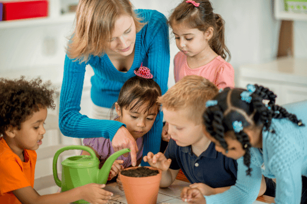 Children planting seeds together in class.