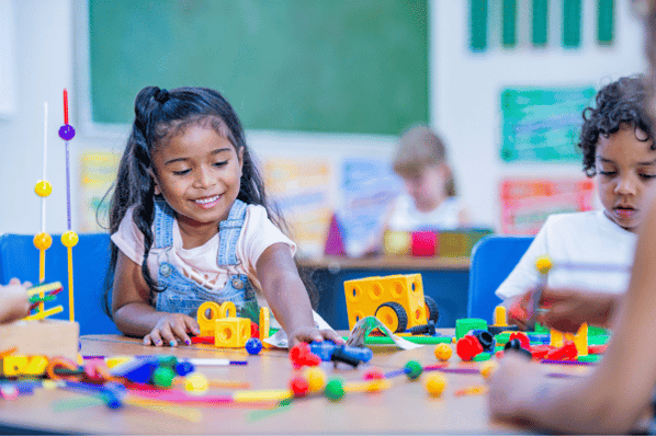 Children playing with toys at table.