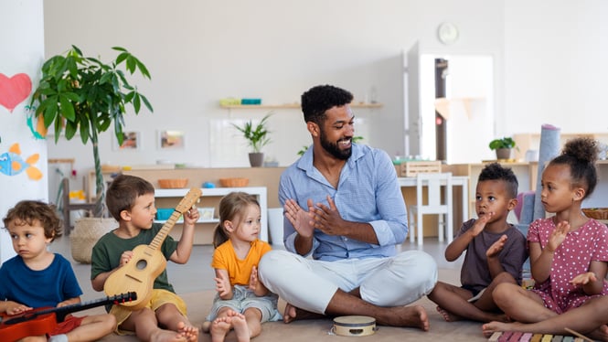 Children are engaged in a social studies activity with a childcare staff.