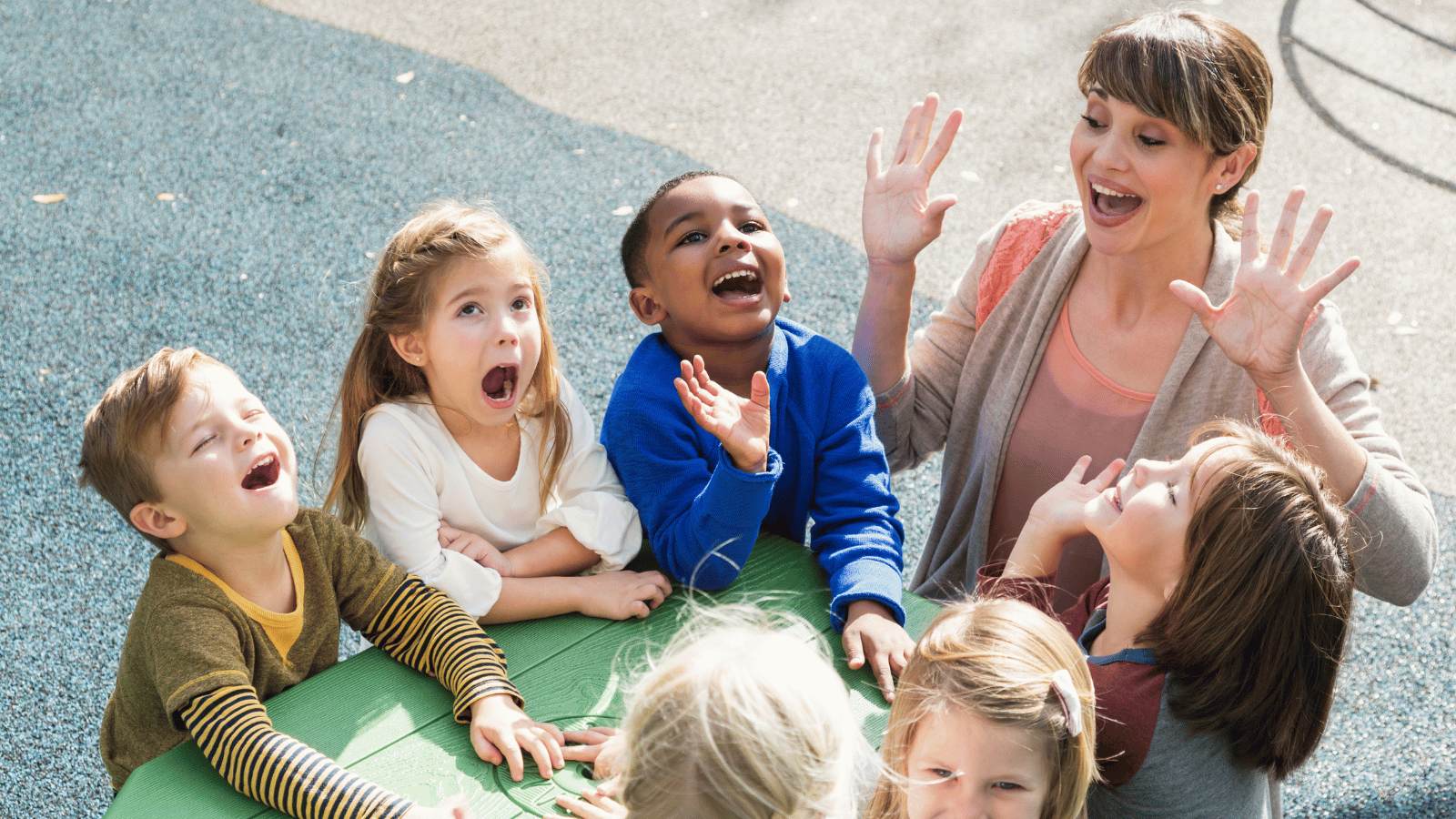 Children engaged in outdoor play with staff supervision